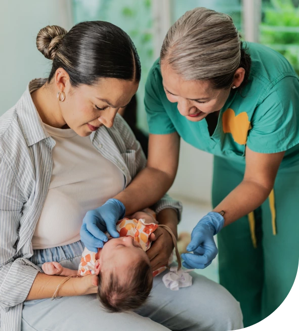 Mom with nurse carefully aiding baby